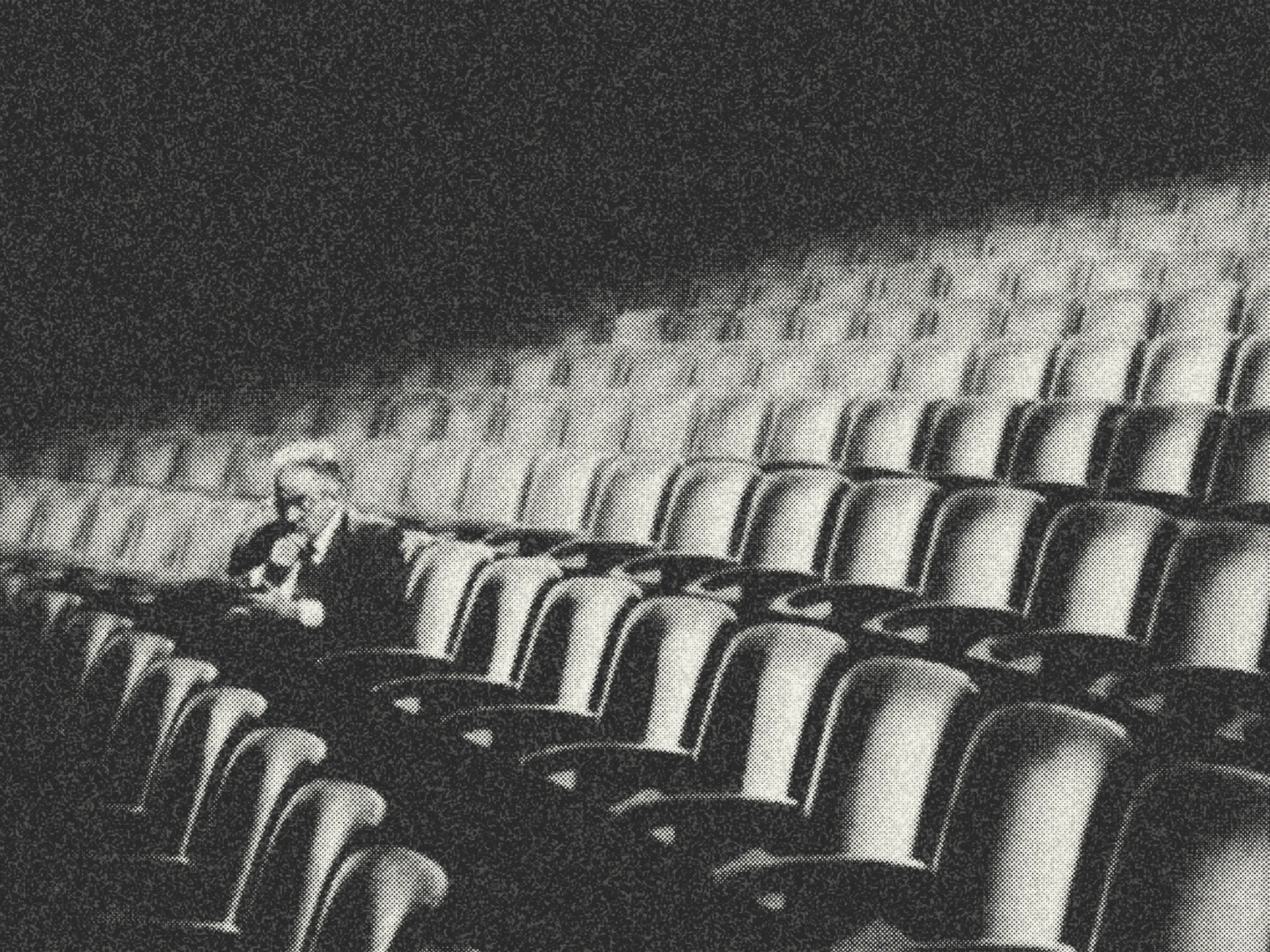 A man sitting alone in a theater.